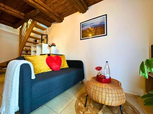 ein Wohnzimmer mit einem blauen Sofa und einem Tisch in der Unterkunft Le petit Châtaignier - Cozy Immo in Châtenois
