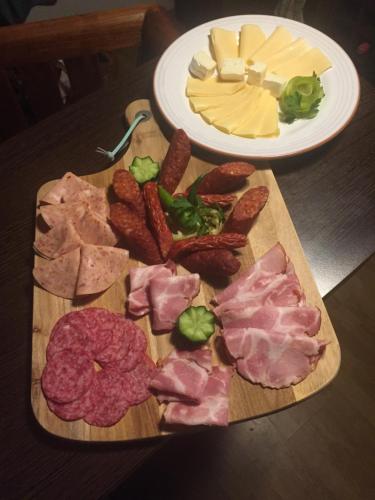 a cutting board with meats and cheese on a table at Apartman-Donau Tát in Tát