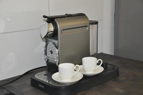 a coffee machine with two cups on a table at Panorama Garten-Apartment in Marburg in Marburg an der Lahn
