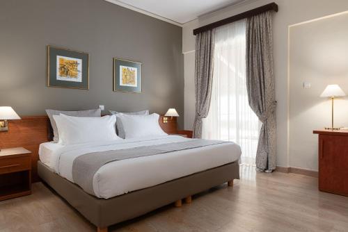 a bedroom with a large bed and a window at Acropolis Select in Athens