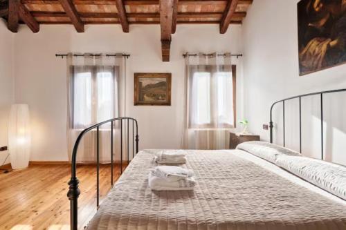 a bedroom with a bed in a room with windows at Villa Navagero - Ca' degli Stefani C in Rovarè