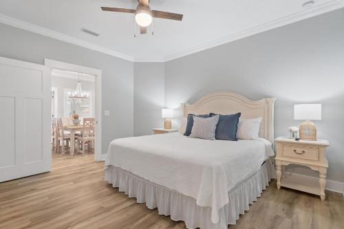1 dormitorio blanco con 1 cama y comedor en Barefoot Bungalow at Rookery, en Gulf Shores