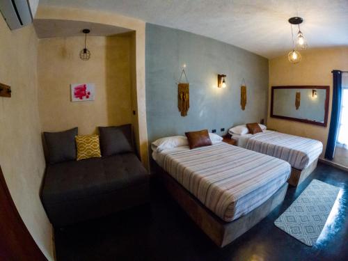 une chambre d'hôtel avec deux lits et une chaise dans l'établissement relax hotelito, à Cárdenas