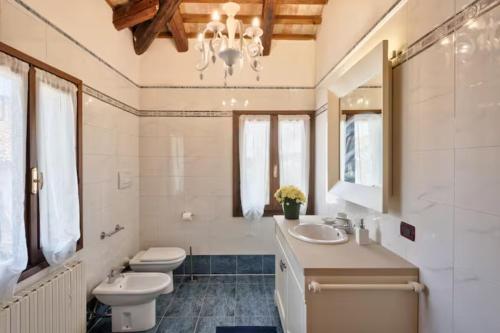 baño con lavabo, aseo y lámpara de araña en Villa Navagero - Ca' degli Stefani C en Rovarè