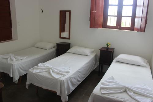 a room with two beds with white sheets and a window at Pousada Convento da Conceição in Olinda