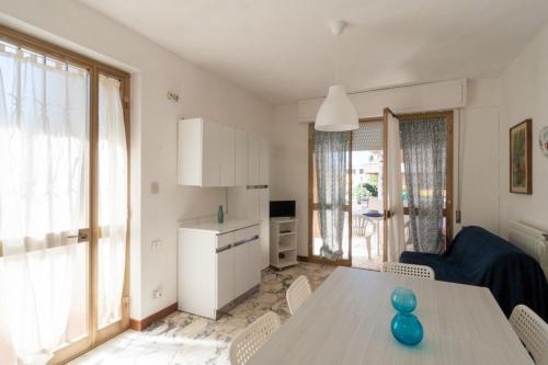 Il comprend une cuisine et un salon avec une table et des chaises. dans l'établissement appartamenti PALMARIA, à Follonica