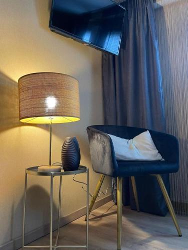 a lamp sitting next to a chair and a table at Villa Pauline - FeWo "Champagne" in Bad Sooden-Allendorf
