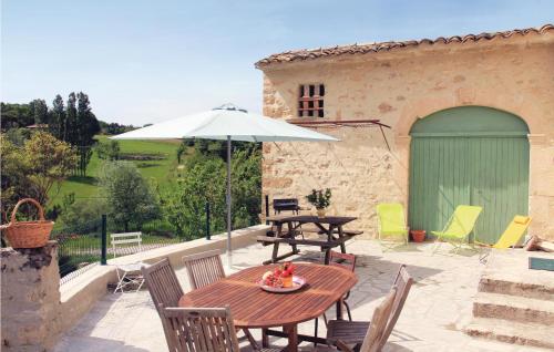 a patio with a table and an umbrella at Awesome Home In Montjoux in Montjoux