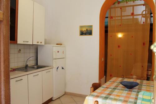 una pequeña cocina con mesa y fregadero en Appartamenti Stella, en Lipari