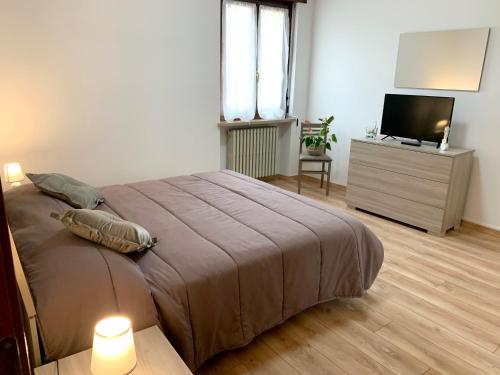 - une chambre avec un grand lit et une télévision dans l'établissement La Cicala - appartamento con giardino privato, à Rivoli Veronese