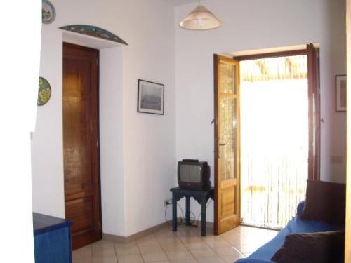 sala de estar con puerta y TV en Appartamenti Stella en Lipari