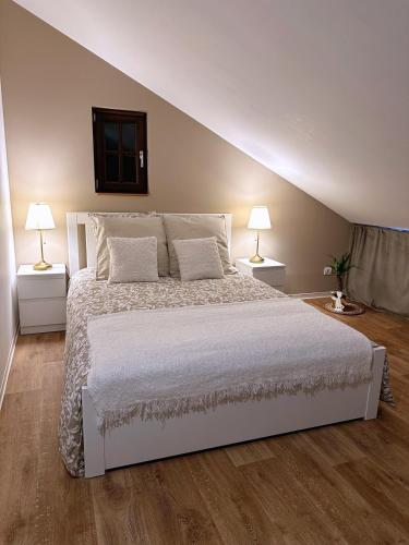 a bedroom with a large white bed with two lamps at Le petit Châtaignier - Cozy Immo in Châtenois