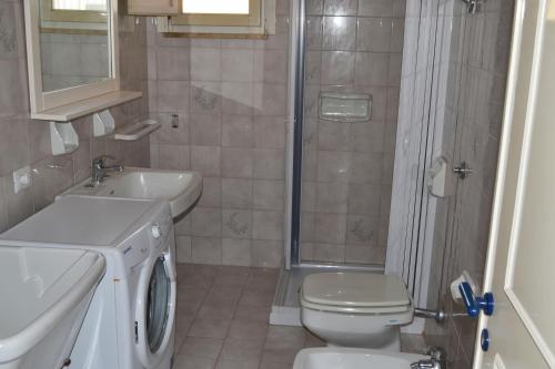 uma casa de banho com um WC, um lavatório e um chuveiro em Apt 7 Posti Vicino Spiaggia em San Foca