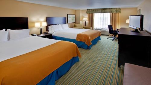 a hotel room with two beds and a flat screen tv at Holiday Inn Express- Waterloo/Cedar Falls by IHG in Waterloo