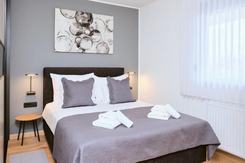 1 dormitorio con 1 cama con 2 toallas en apartman Azul, en Čakovec