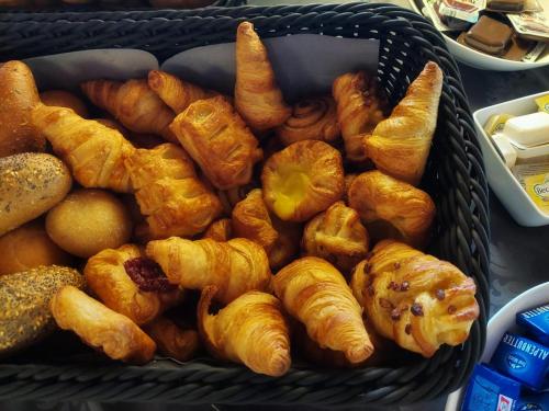a basket full of croissants and other pastries at Sporthotel Austria in Sankt Johann in Tirol