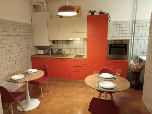 a kitchen with two tables and red cabinets at Fenix Rooms in Trieste
