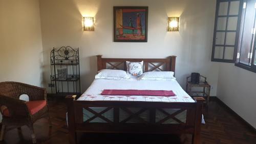 1 dormitorio con 1 cama y 1 silla en Secluded luxury villa with pool views privacy en Rivière Noire