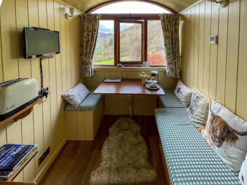 a small room with a table and a window at 5 Star Shepherds Hut in Betws y Coed with Mountain View in Capel-Curig