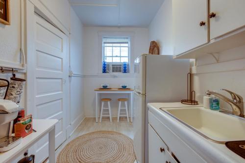 a white kitchen with a sink and a refrigerator at Walkable Savannah Escape in Historic District! in Savannah