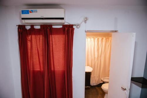 a room with a red curtain and a television at Hotel Rosario in Mendoza