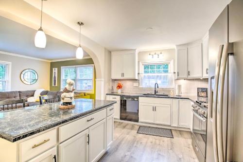 a kitchen with white cabinets and a large island at Overland Park Home with Deck and Waterfall Pond! in Overland Park