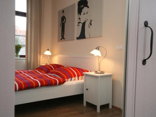 a bedroom with a bed and two lamps and a window at Pension Alba in Görlitz