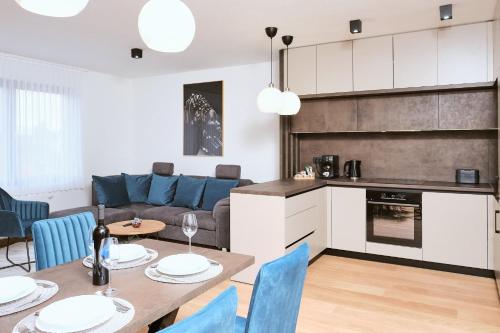 cocina y sala de estar con mesa y sillas en apartman Azul, en Čakovec