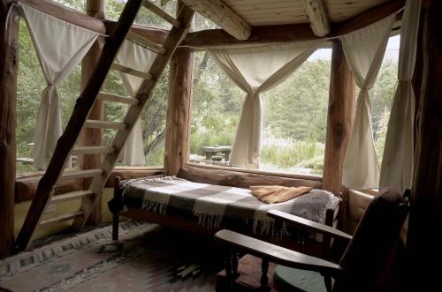 una camera da letto con un letto in una stanza con una finestra di Cabaña Las Tejas a El Bolsón