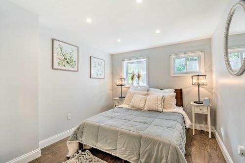 a bedroom with a bed with two tables and two windows at Central and Trendy Baltimore Townhome Pets OK! in Baltimore