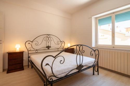 a bedroom with a metal bed and a window at Appartamenti PEN in Follonica