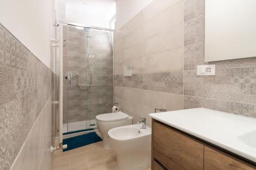 a bathroom with a toilet and a shower and a sink at Appartamenti PEN in Follonica