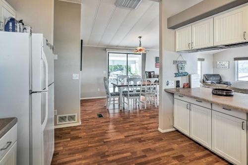 a kitchen with a white refrigerator and a table at Sun-Dappled AZ Abode with River and Mtn Views! in Parker