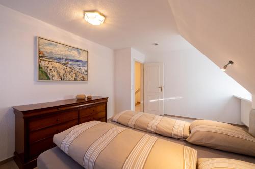 ein Schlafzimmer mit 2 Betten und einem Wandgemälde in der Unterkunft Herzogs Friesenhaus in Südstrand