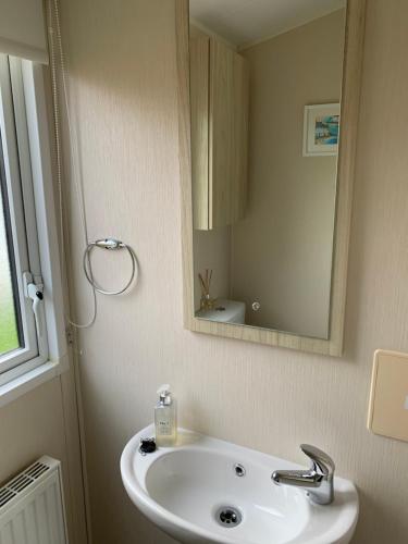 a bathroom with a sink and a mirror at Newquay Bay Resort 63 in Newquay Bay Resort