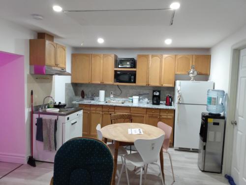 uma cozinha com uma mesa e um frigorífico branco em Healing Touch Holistic Living Space em Amherst