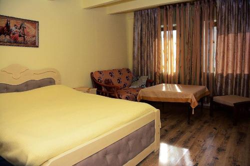 Pokój hotelowy z łóżkiem i krzesłem w obiekcie The view of gora w Kutaisi
