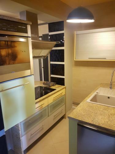 een keuken met een wastafel en een fornuis top oven bij Apartament Loft in Radom