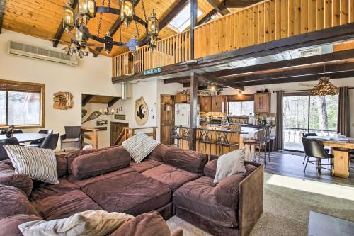 a living room with a couch and a kitchen at Swiss-Style Chalet with Fireplace - Near Story Land! in Bartlett