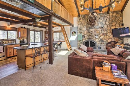 a living room with a couch and a stone wall at Swiss-Style Chalet with Fireplace - Near Story Land! in Bartlett