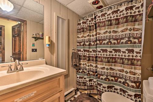ein Bad mit einem Waschbecken und einem Duschvorhang in der Unterkunft Swiss-Style Chalet with Fireplace - Near Story Land! in Bartlett