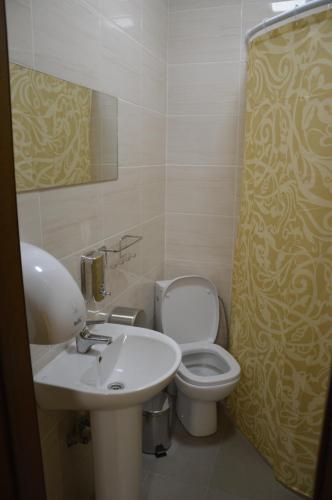 uma casa de banho com um lavatório, um WC e um chuveiro em Хостел ПІД ФІКУСОМ em Ivano-Frankivsk