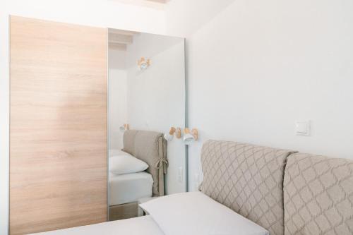 a mirror in a room with a bed and a chair at PETRINO FOINIKOUNTA in Finikounta