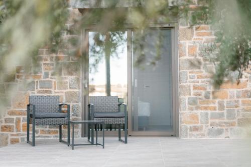 three chairs and a table in front of a door at PETRINO FOINIKOUNTA in Finikounta