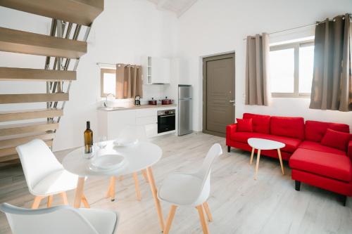 a living room with a red couch and a table and chairs at PETRINO FOINIKOUNTA in Finikounta