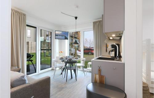 eine Küche und ein Wohnzimmer mit Tisch und Stühlen in der Unterkunft Cozy Apartment In Lembruchdümmer See in Lembruch
