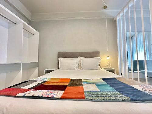 een slaapkamer met een bed met een kleurrijke quilt bij YOUROPO - Capela in Porto