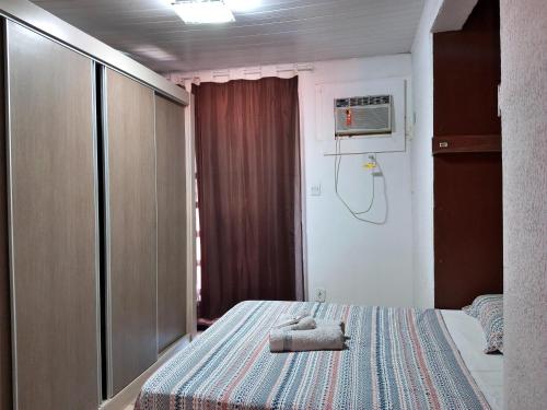 una camera da letto con un letto e due asciugamani di Conforto 100 mts da praia a Barra de São Miguel