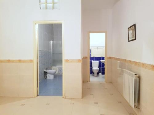 an empty bathroom with two toilets and a sink at Appartement 200 m 2 + 5 min du c.c.o in Oran