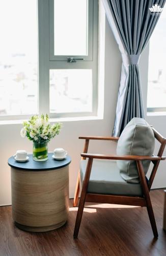 a living room with a chair and a table at Cali Hotel Quy Nhơn in Quy Nhon